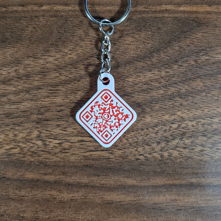 Red QR code keychain hanging on a wood background