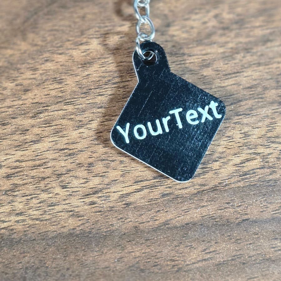 Black keychain tag engraved with custom text
